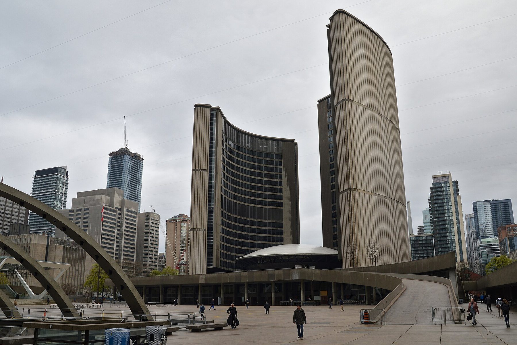 Toronto City Hall, two curved concrete towers around a low domed council chamber, seen across Nathan Phillips Square