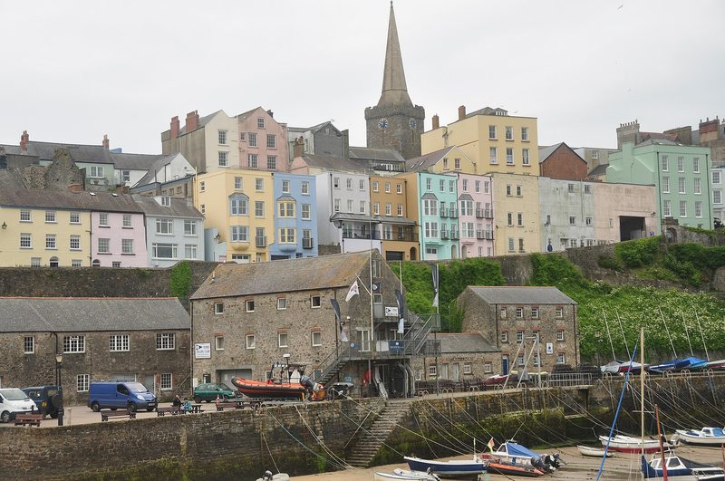 Tall painted houses above a harbour wall in a Welsh seaside town, seen from the harbour