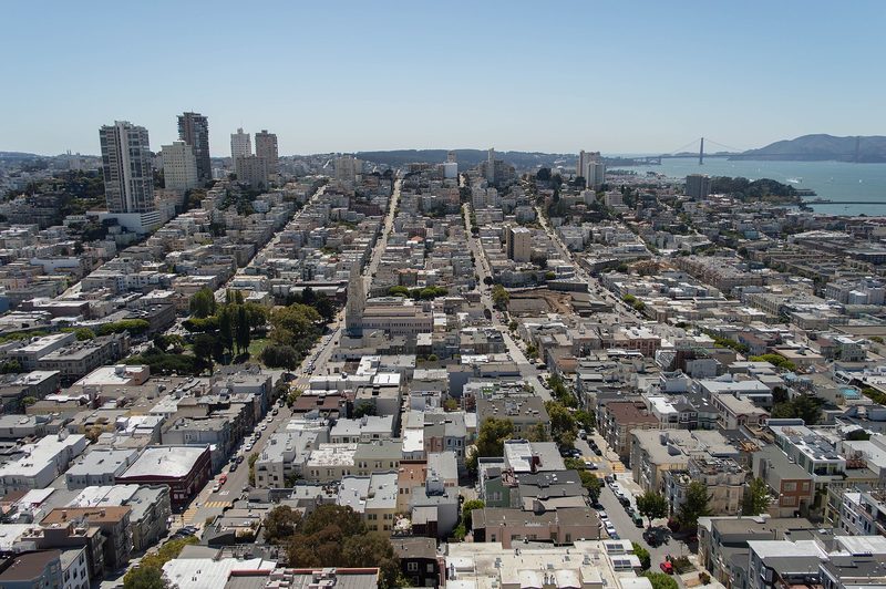 San Francisco seen from Coit Tower: streets of low apartment buildings and houses climbing a hill, with the bay beyond