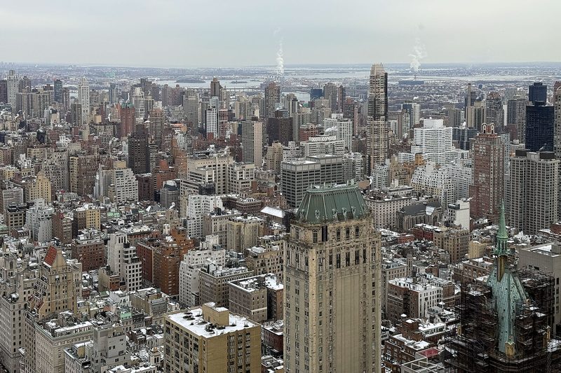 High view across blocks of apartment buildings on Manhattan's Upper East Side, with the East River and Queens in the distance