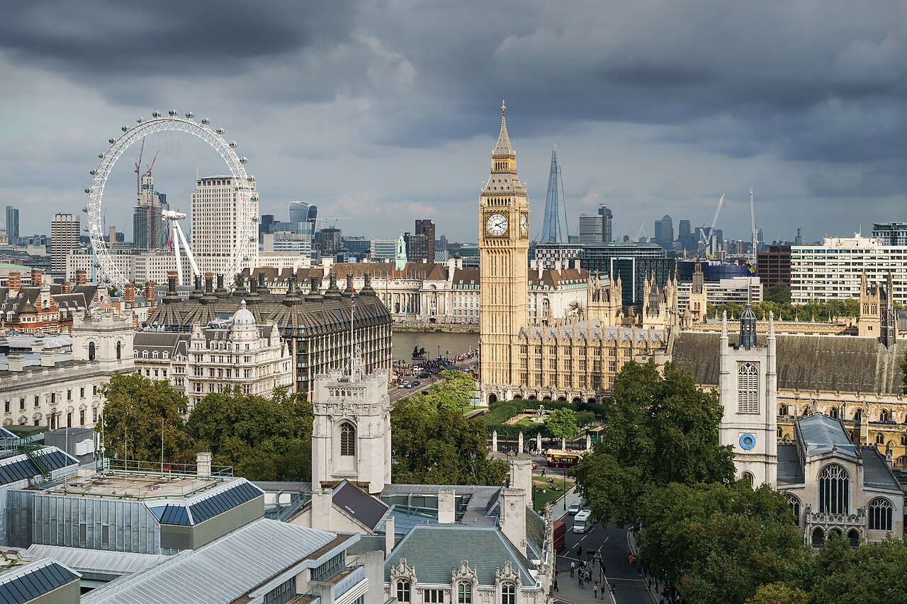 A rooftop view over Westminster with the clock tower in the centre and the London Eye to the left.